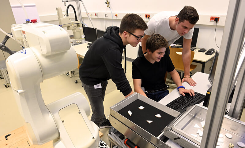 Teilnehmer des Camps bei der Roboterprogrammierung
Bildquelle: Jan-Peter Kasper, Friedrich-Schiller-Universität Jena